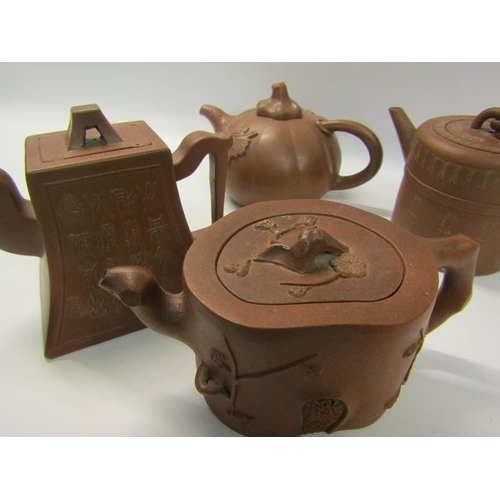 356 - A collection of four 19c Oriental red clay teapots with applied moulded decoration, two with panels ... 