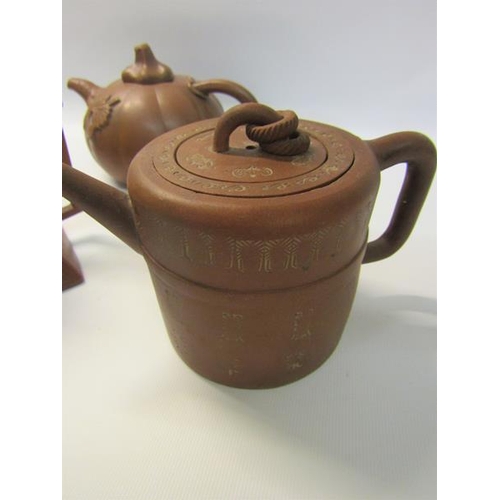 356 - A collection of four 19c Oriental red clay teapots with applied moulded decoration, two with panels ... 