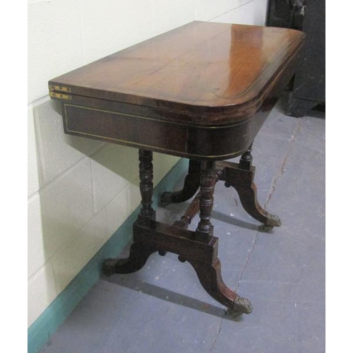 544 - A late Georgian figured mahogany fold over card table the table top with brass rail inlay cross band... 