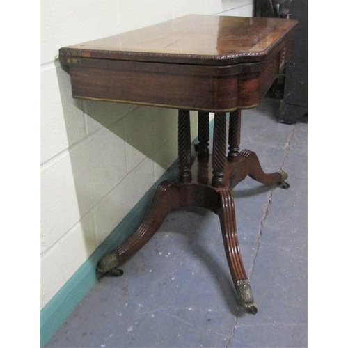 545 - A Regency rosewood fold over card table with brass rail inlay raised on a stretcher frame with ring ... 