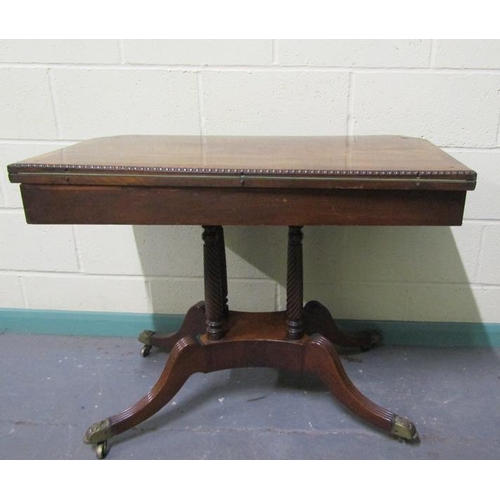 545 - A Regency rosewood fold over card table with brass rail inlay raised on a stretcher frame with ring ... 