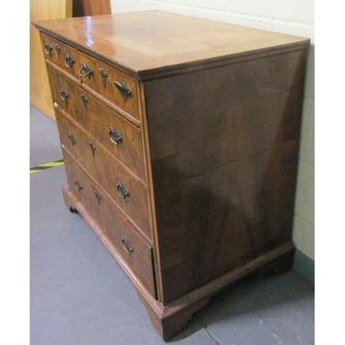 546 - An 18c figured walnut chest of two short and three long graduated drawers.  The top with wide cross ... 