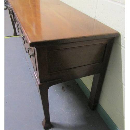 608 - An early 19c Cherrywood four drawer dresser base with fret cut apron supported on square carved tape... 