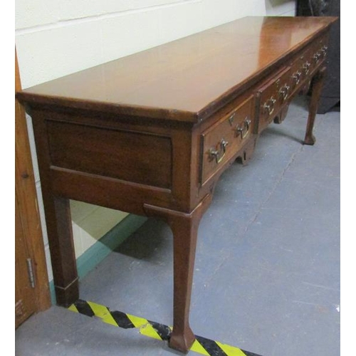 608 - An early 19c Cherrywood four drawer dresser base with fret cut apron supported on square carved tape... 