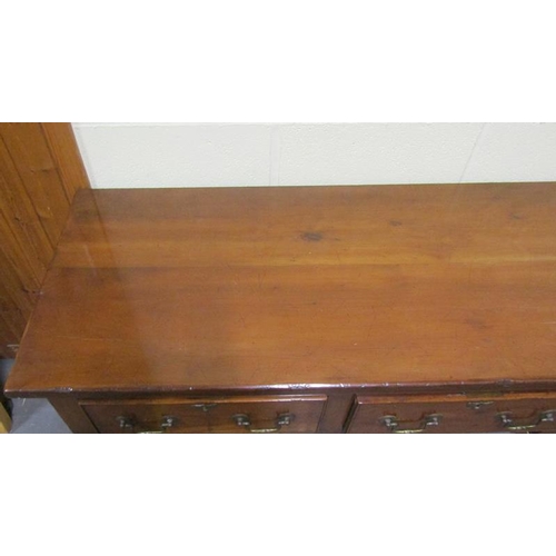 608 - An early 19c Cherrywood four drawer dresser base with fret cut apron supported on square carved tape... 