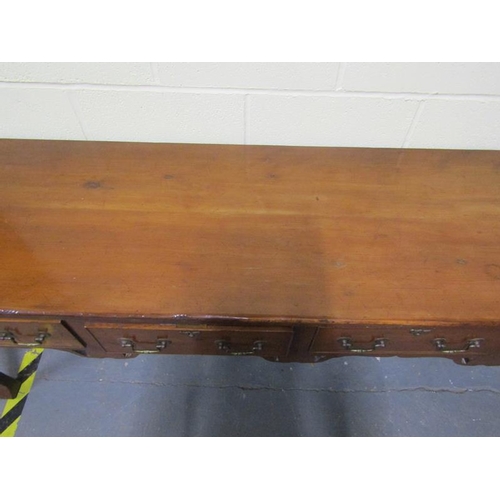 608 - An early 19c Cherrywood four drawer dresser base with fret cut apron supported on square carved tape... 