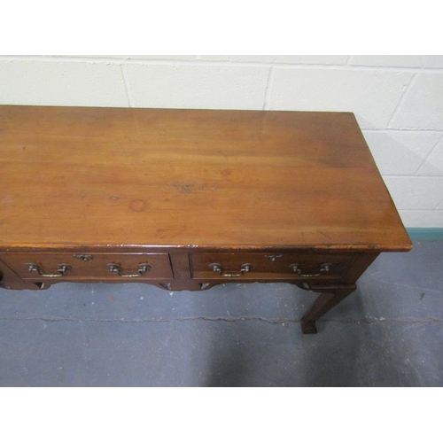 608 - An early 19c Cherrywood four drawer dresser base with fret cut apron supported on square carved tape... 