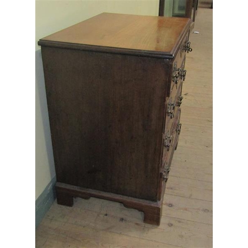 549 - A late Georgian mahogany chest of four long drawers with cut brass back plates and swing handles.  O... 