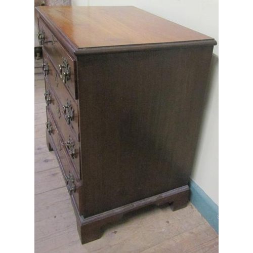 549 - A late Georgian mahogany chest of four long drawers with cut brass back plates and swing handles.  O... 