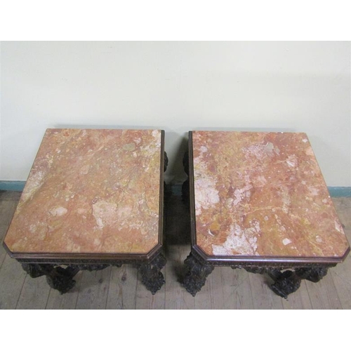 553 - A pair of 19c Continental marble top low tables on carved wood and stucco decorated frames, each wit... 