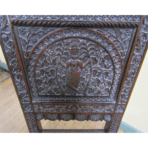 561 - A 19c Indian side chair with a figurative carved back panel within profuse leaf and flower under a s... 