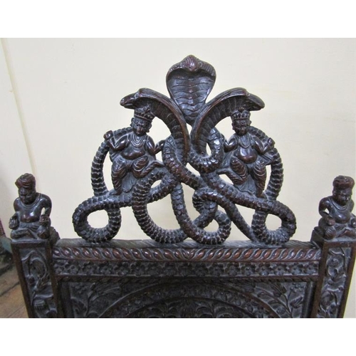 561 - A 19c Indian side chair with a figurative carved back panel within profuse leaf and flower under a s... 