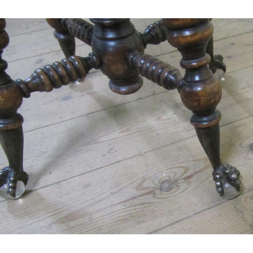 562 - A Victorian oak revolving piano stool supported on four ring turned legs with claw and glass ball fe... 