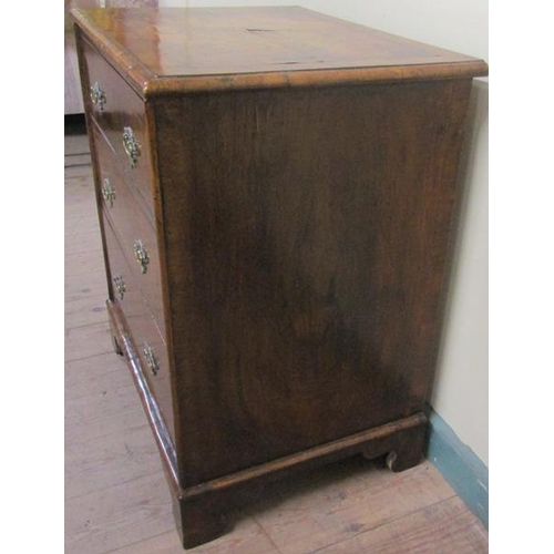 575 - A mid Georgian style figured walnut veneered small chest of three long drawers.  The top and drawer ... 