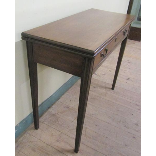 586 - A late Georgian mahogany fold over table of rectangular form with moulded edge having one long friez... 