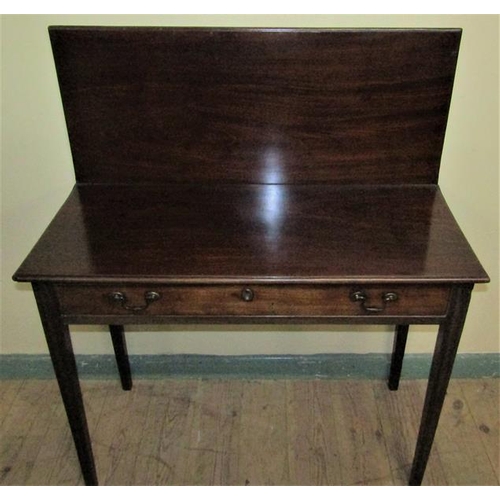 586 - A late Georgian mahogany fold over table of rectangular form with moulded edge having one long friez... 