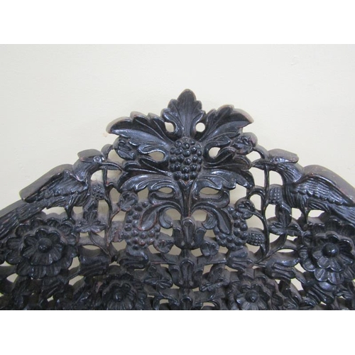 615 - Early 19c Indian ebony low chair the base of circular form, profusely carved apron.  The legs are ca... 