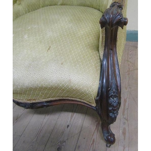 616 - A mid Victorian walnut show frame and button upholstered armchair, the down swept arms with scroll a... 