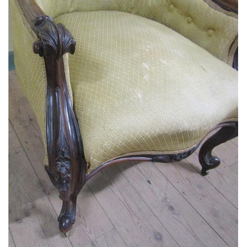 616 - A mid Victorian walnut show frame and button upholstered armchair, the down swept arms with scroll a... 