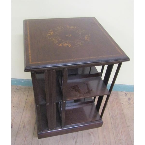 536 - A late 19c/early 20c mahogany revolving bookcase, the top with marquetry motif within satinwood and ... 