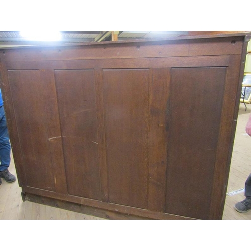 577 - A late 19c/early 20c oak breakfront standing bookcase with fitted shelves and enclosed by glazed doo... 