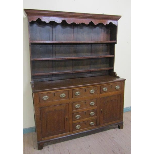 602 - An early 18c English oak three drawer dresser with a panel back rack having three open shelves under... 