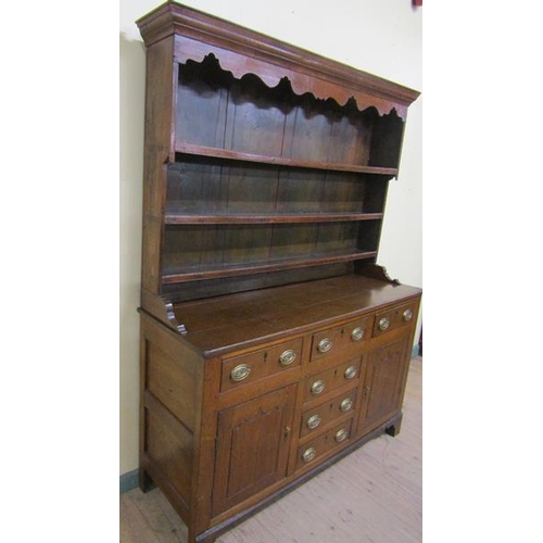 602 - An early 18c English oak three drawer dresser with a panel back rack having three open shelves under... 