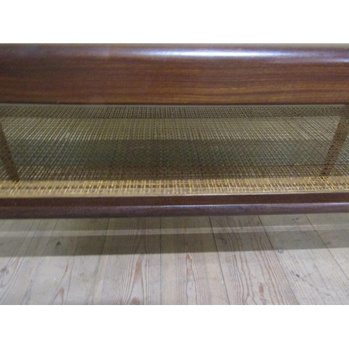 623 - A 1970s teak low table of rectangular form with a caned under tier shelf, supported on straight tape... 