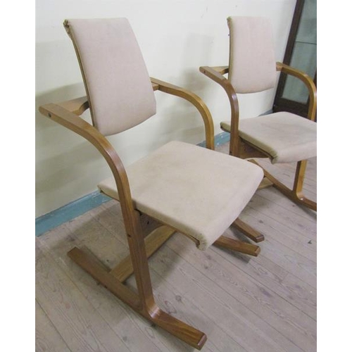 629 - A pair of 1970's plywood upholstered rocking armchairs.