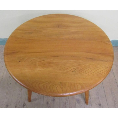 631 - An Ercol teak circular low table on four splayed baluster legs.  75cms d x 46cms h.