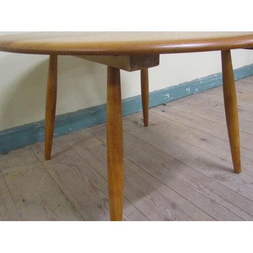 631 - An Ercol teak circular low table on four splayed baluster legs.  75cms d x 46cms h.