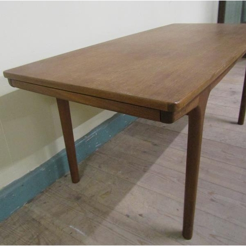 632 - A 1970's teak low table of rectangular shaped form with two pull out end shelves and supported on ci... 