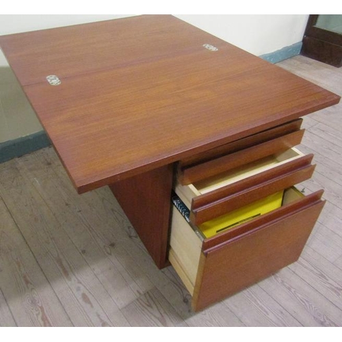 638 - A 1970's teak office cabinet by Ideal Heim with hinged fold over revolving table top and having thre... 