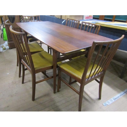 640 - A 1970's teak dining table together with a set of six spindle back dining chairs with faux leather u... 