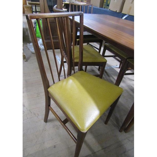 640 - A 1970's teak dining table together with a set of six spindle back dining chairs with faux leather u... 