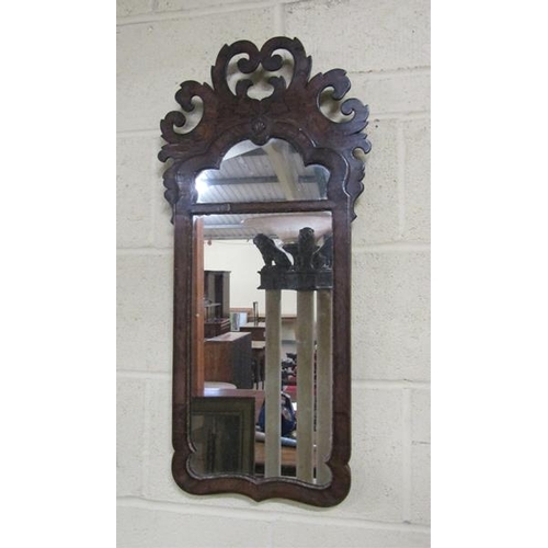 589 - A William and Mary style figured walnut veneered wall mirror with open scrolling pediment, arched up... 