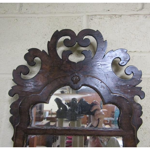 589 - A William and Mary style figured walnut veneered wall mirror with open scrolling pediment, arched up... 