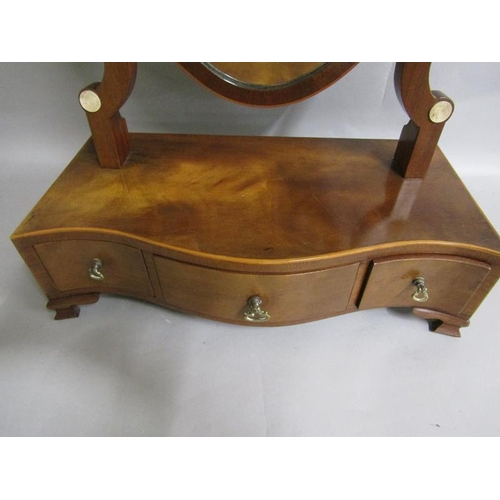 590 - A late Georgian mahogany shield shaped toilet glass on a serpentine base fitted three short drawers ... 