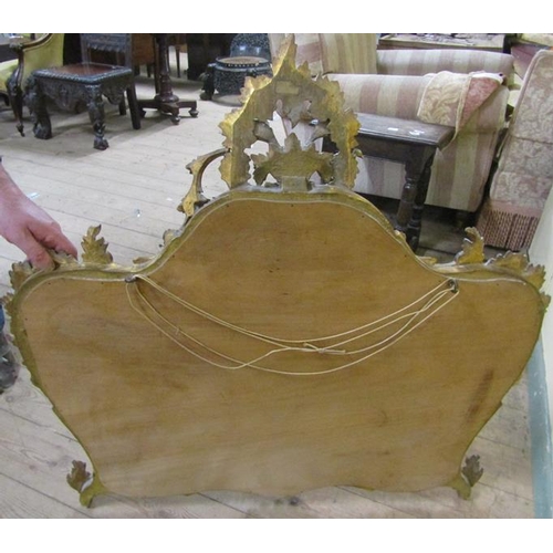 592 - A mid Georgian style gilt wooden stucco wall mirror with a rising leaf and scroll pediment within a ... 