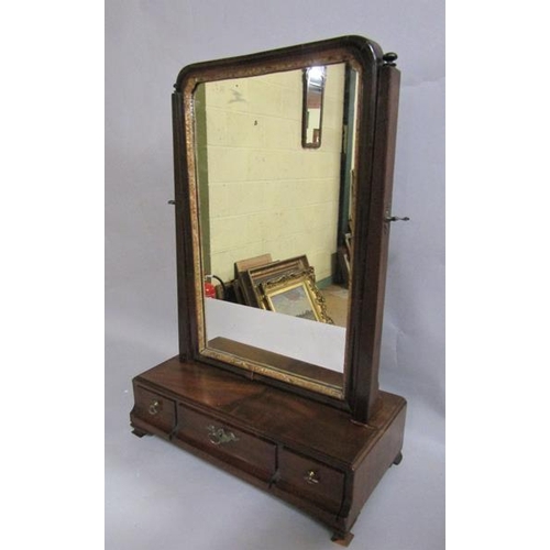 594 - A George III figured mahogany toilet glass with gilt border, adjustable and supported on base with f... 