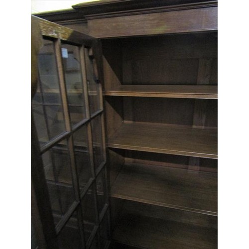 577 - A late 19c/early 20c oak breakfront standing bookcase with fitted shelves and enclosed by glazed doo... 