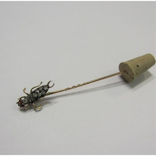 185 - A gold stick pin with Diamond and Ruby set insect terminal.  6cms l.