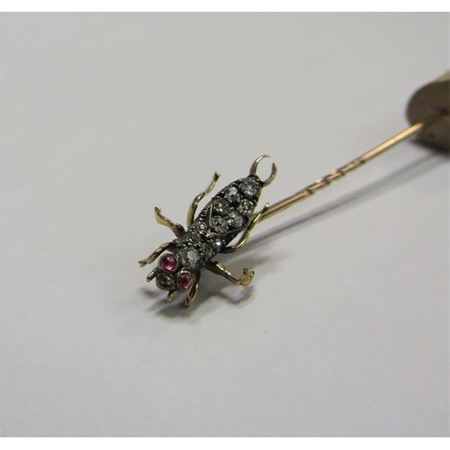 185 - A gold stick pin with Diamond and Ruby set insect terminal.  6cms l.