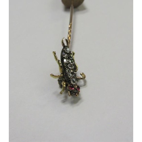 185 - A gold stick pin with Diamond and Ruby set insect terminal.  6cms l.