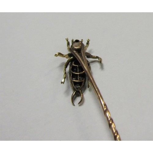 185 - A gold stick pin with Diamond and Ruby set insect terminal.  6cms l.