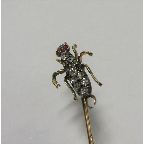 185 - A gold stick pin with Diamond and Ruby set insect terminal.  6cms l.