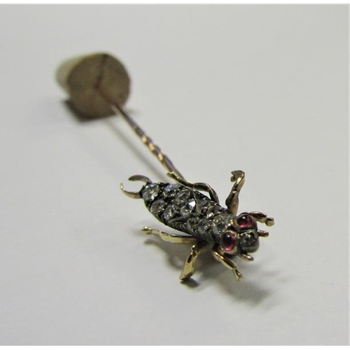 185 - A gold stick pin with Diamond and Ruby set insect terminal.  6cms l.