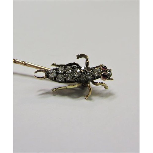 185 - A gold stick pin with Diamond and Ruby set insect terminal.  6cms l.