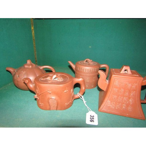 356 - A collection of four 19c Oriental red clay teapots with applied moulded decoration, two with panels ... 