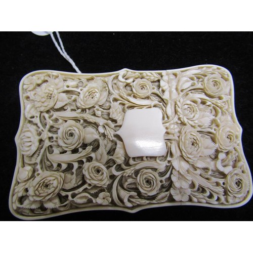 115 - A late 19c ivory card case carved in high relief with panels of leaf and flowers, and through the re... 